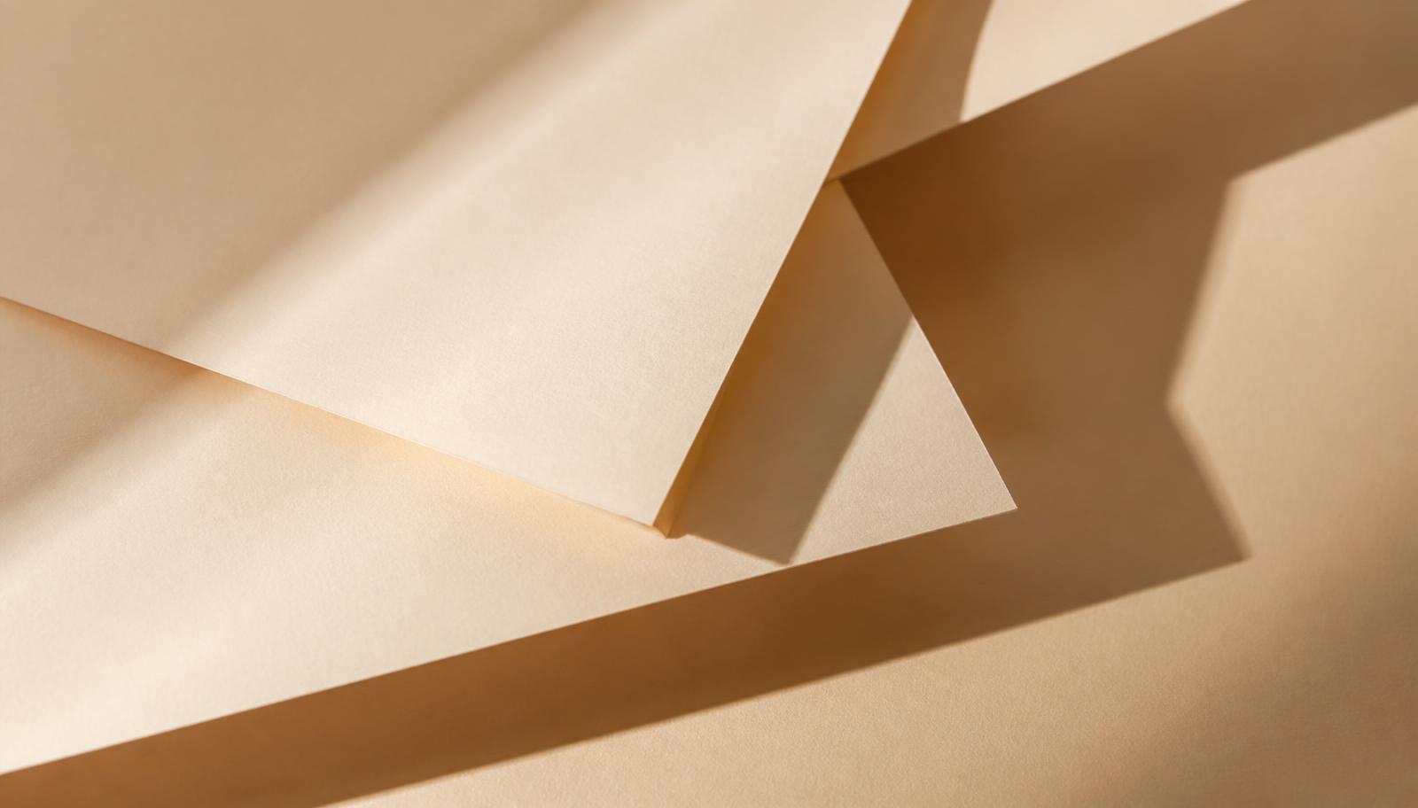 Layered warm beige paper sheets with soft shadows